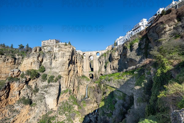 Bridge Puente Nuevo with waterfall at steep cliffs