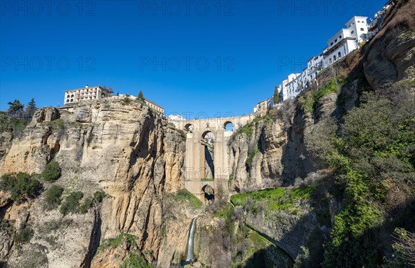 Bridge Puente Nuevo with waterfall at steep cliffs