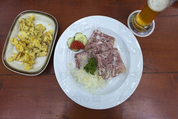 Brawn with fried potatoes and wheat beer on a beer table