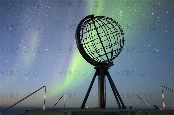 Steel globe at North Cape with northern lights