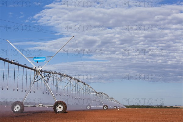 Pivot Sprinklers spread water on cotton harvested fields