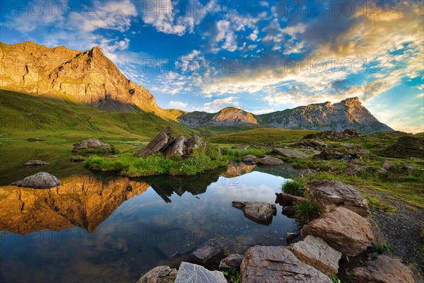 Reflection of the mountains and clouds in the Blausee at sunrise