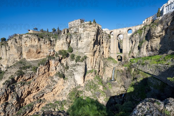 Bridge Puente Nuevo with waterfall at steep cliffs