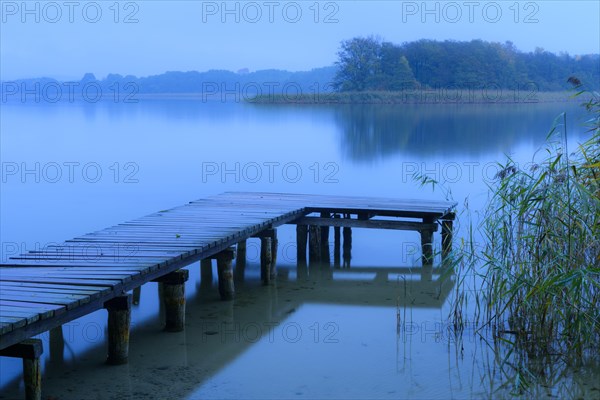 Jetty and landing stage at the lake Breiter Luzin at the blue hour
