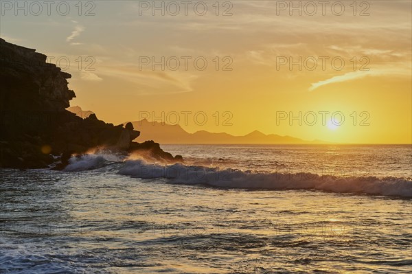 Beach Playa de la Pared with rocky coast at sunset