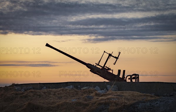 Anti-aircraft gun position at the sea from the 2nd world war against the light of the evening sun