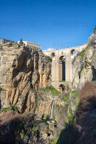 Bridge Puente Nuevo with waterfall at steep cliffs