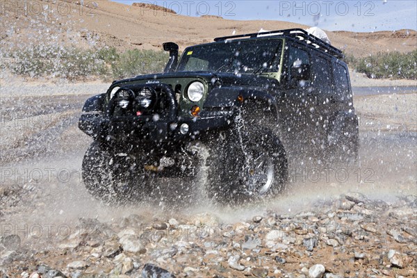 Off-road vehicle crosses a river in the Middle Atlas