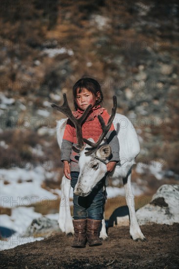 Reindeer herder girl with baby reindeer. Ulaan taiga mountains. Khuvsgul province