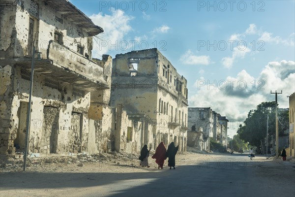 Somali women walking through the streets of the destroyed houses of Mogadishu