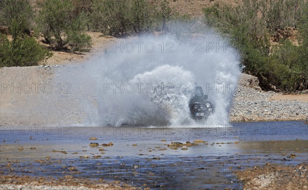 Off-road vehicle crosses a river in the Middle Atlas