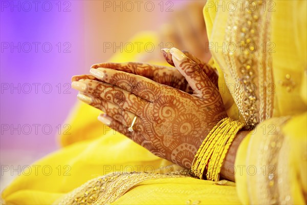Hindu Bride crossing hands painted with henna for prayer on wedding eve