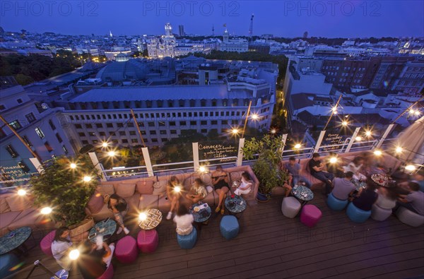Groups and couples enjoy a summer night at the terrace bar of Casa Suecia Hotel in Madrid