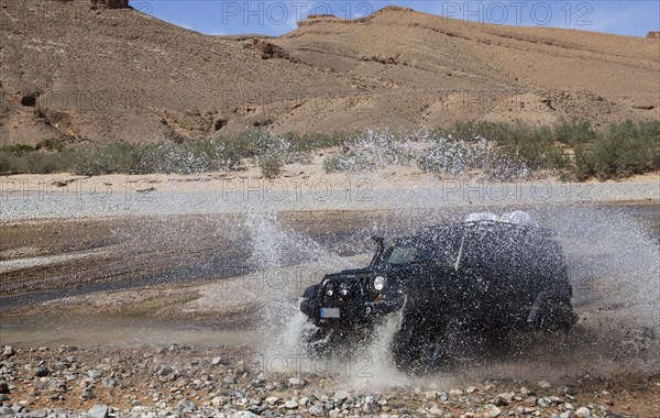 Off-road vehicle crosses a river in the Middle Atlas