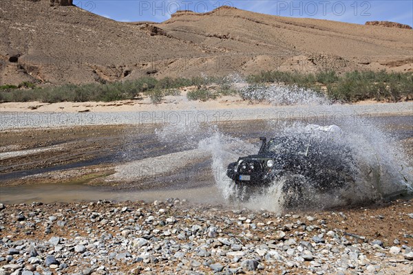 Off-road vehicle crosses a river in the Middle Atlas