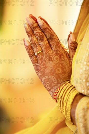 Hindu Bride crossing hands painted with henna for prayer on wedding eve