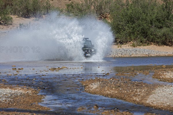 Off-road vehicle crosses a river in the Middle Atlas