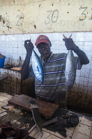 Somali man offering his fish in the Fishmarket