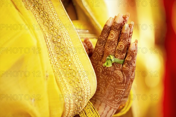 Hindu Bride crossing hands painted with henna for prayer on wedding eve