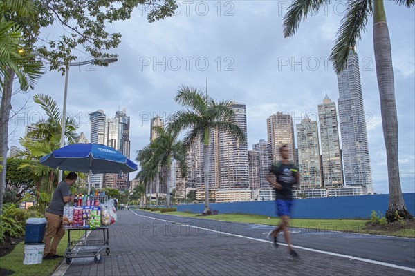 Street vendors and joggers on the sidewalk next to Balboa Avenue