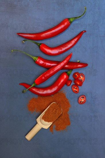 Chili powder in wooden shovel and chilli peppers
