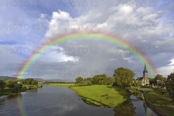 Rainbow over the Weser with catholic church and old harbour