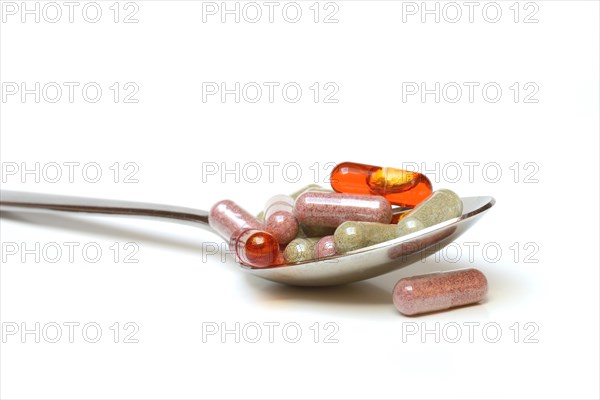 Capsules with food supplements in spoon