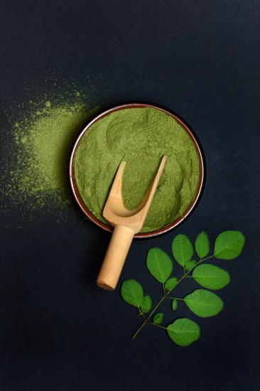 Moringa powder in bowl and Moringa leaves