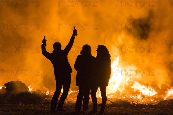 Silhouettes of three people at an Easter fire