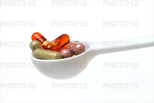 Capsules with food supplements in porcelain spoon