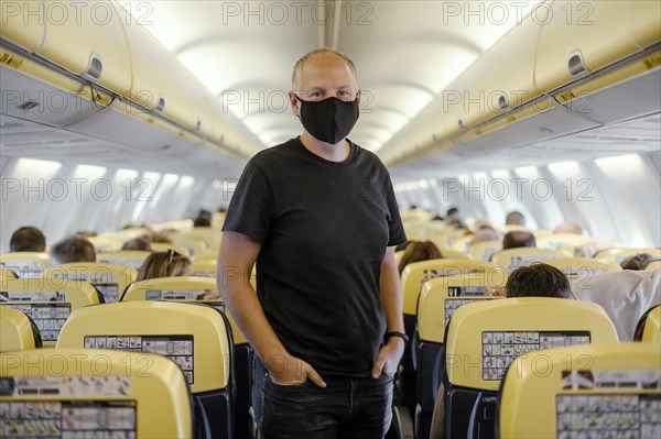 Man in protective mask standing in airplane