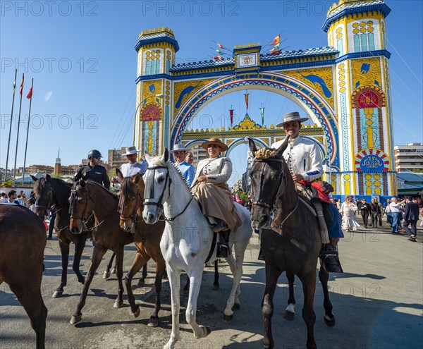 Riders on decorated horses in traditional dress in front of the entrance gate