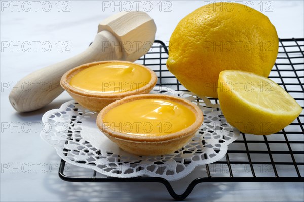 Lemon tartlets and lemon on a cake rack