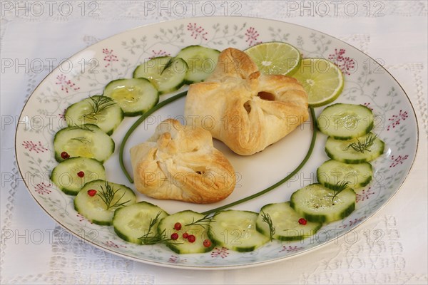 Puff pastry pocket enriched with cucumbers and slices of lime on plates