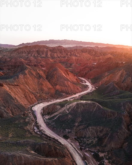 Red sandstone mountains of different minerals with a road in the foreground