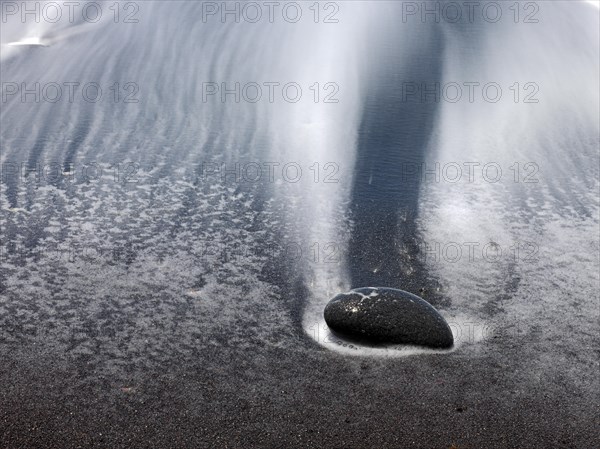 Black stones and sand with run-off water