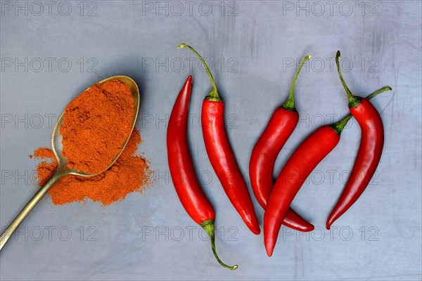 Chili powder in spoon and chilli peppers