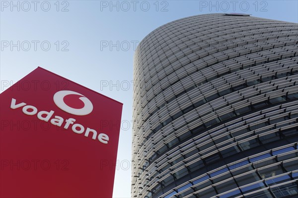 Pillar with Vodafone logo in front of the Vodafone high-rise building