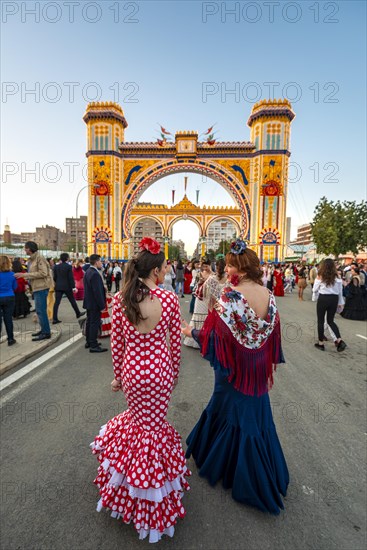 Spanish women with flamenco dresses in front of the illuminated Portada