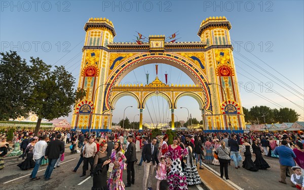 Traditionally dressed Spaniards with flamenco dresses in front of the illuminated Portada