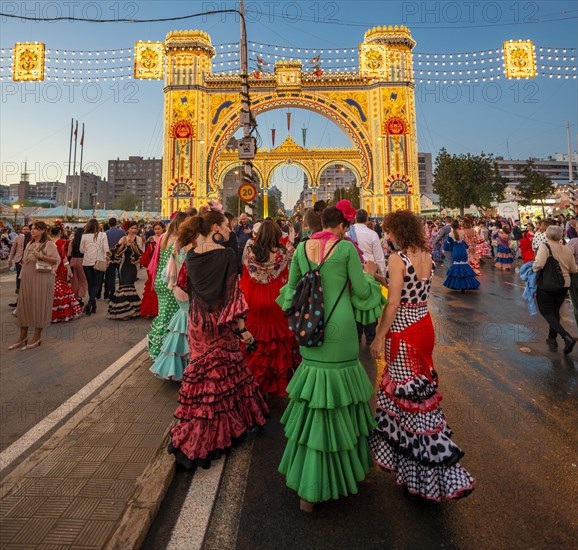 Spanish women with flamenco dresses in front of the illuminated Portada