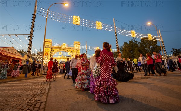 Spanish women with flamenco dresses in front of the illuminated Portada