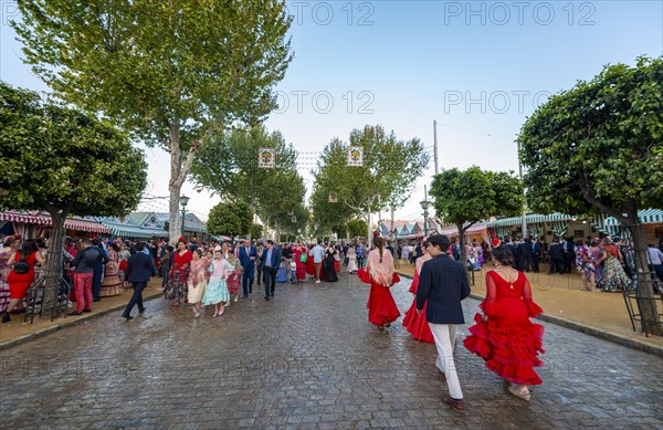 Celebrating Spaniards in traditional dress in front of marquees