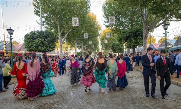 Celebrating Spaniards in traditional dress in front of marquees