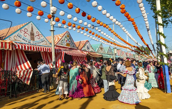 Celebrating Spaniards in traditional dress in front of marquees