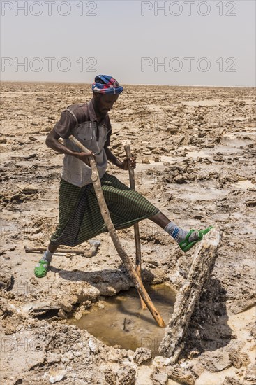 Afar nomad cutting and lifting out salt plates