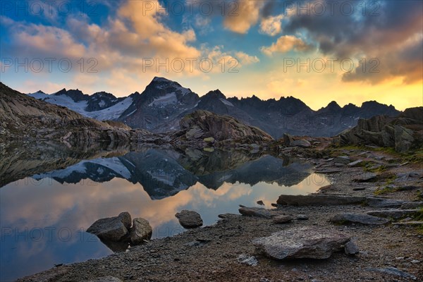 Graetlisee with reflection of the mountains and clouds in the morning light