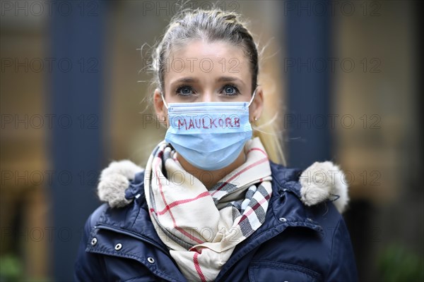 Woman with inscription MAULKORB on face mask