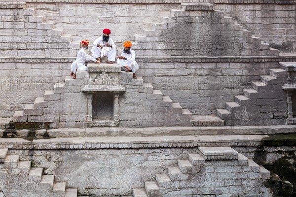 Three men playing cards at the stepwell Toorji Ka Jhalra