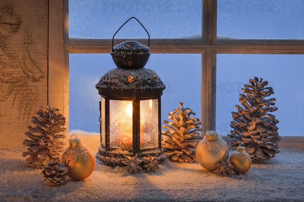 Lantern with Christmas decoration on windowsill